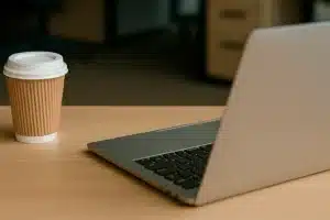 Minimalist office desk with natural light, coffee cup, and laptop – peaceful setup for mindfulness at work
